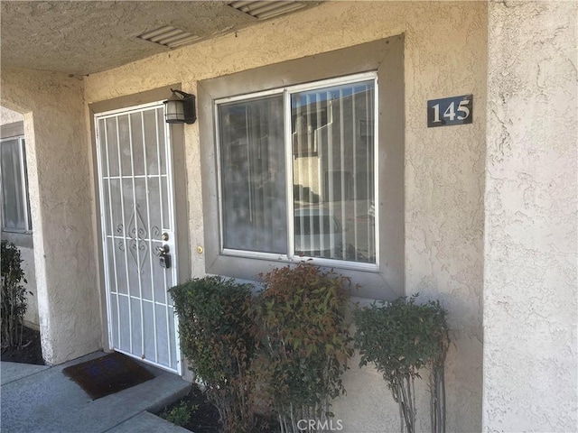 property entrance with stucco siding