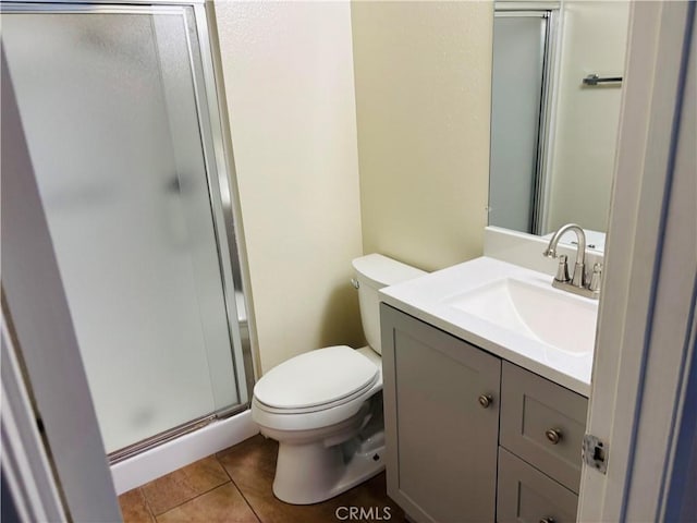 bathroom featuring vanity, tile patterned flooring, a stall shower, and toilet