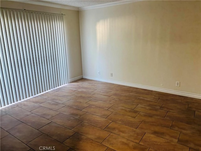 spare room with crown molding and baseboards