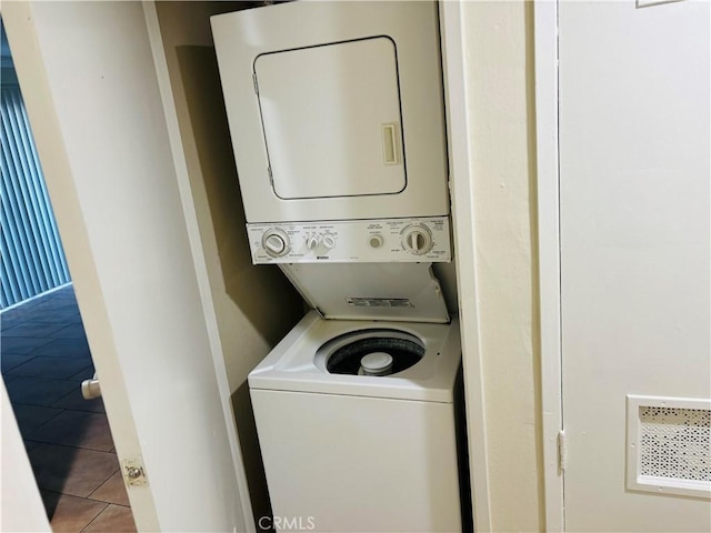 washroom featuring stacked washer and dryer, laundry area, and tile patterned floors