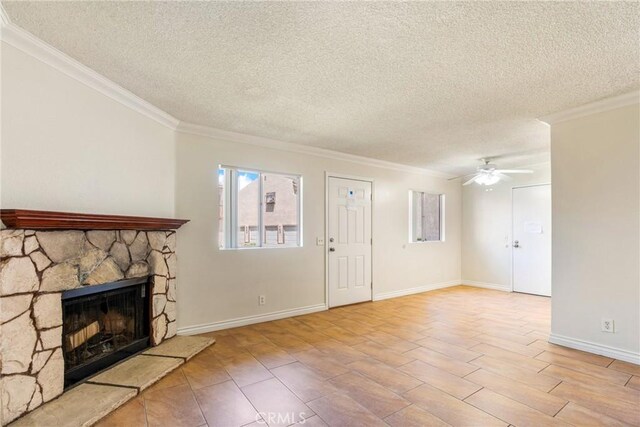 1251 S Meadow Ln Unit 145, Colton, CA 92324 - unfurnished living room featuring a textured ceiling, ornamental molding, ceiling fan, a stone fireplace, and baseboards
