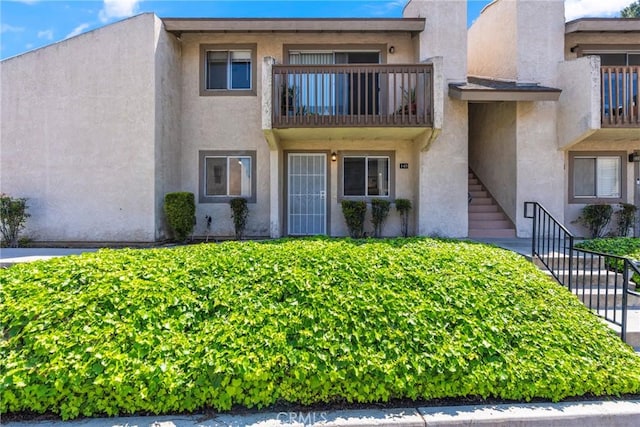 1251 S Meadow Ln Unit 145, Colton, CA 92324 - view of front of property featuring stairs, stucco siding, and a balcony