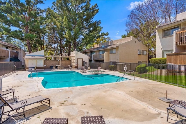 1251 S Meadow Ln Unit 145, Colton, CA 92324 - community pool with fence, a patio area, a residential view, and a storage unit
