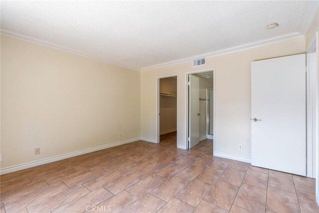 1251 S Meadow Ln Unit 145, Colton, CA 92324 - unfurnished bedroom with a textured ceiling, crown molding, a spacious closet, baseboards, and a closet