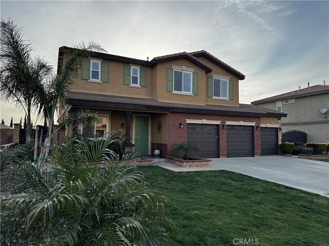 5230 Starling St, Fontana, CA 92336 - view of front facade with stucco siding, a front yard, brick siding, an attached garage, and concrete driveway