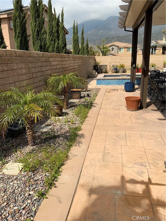 5230 Starling St, Fontana, CA 92336 - view of patio / terrace featuring a mountain view, a fenced backyard, and a fenced in pool