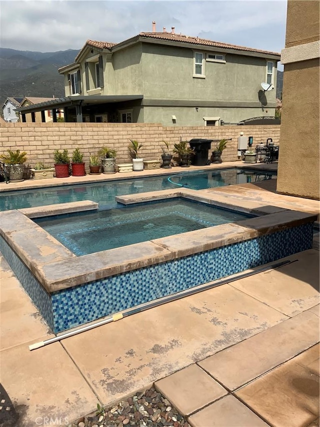 5230 Starling St, Fontana, CA 92336 - view of swimming pool with a mountain view, fence, and an in ground hot tub