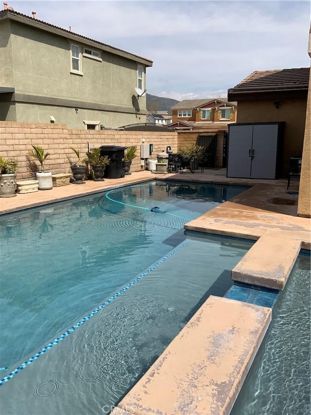 5230 Starling St, Fontana, CA 92336 - view of pool with a fenced in pool, a patio area, a fenced backyard, and an outbuilding