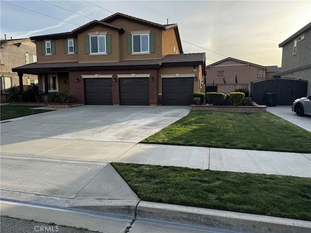 5230 Starling St, Fontana, CA 92336 - craftsman house with a front yard, an attached garage, concrete driveway, stucco siding, and brick siding