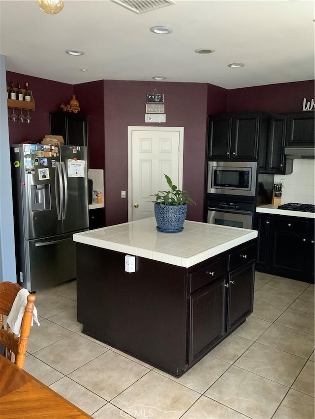 5230 Starling St, Fontana, CA 92336 - kitchen featuring dark cabinets, light tile patterned floors, visible vents, appliances with stainless steel finishes, and tile countertops