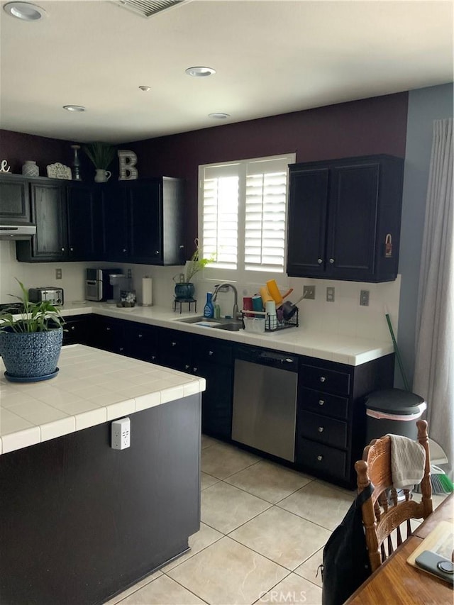 5230 Starling St, Fontana, CA 92336 - kitchen featuring dark cabinets, light tile patterned floors, extractor fan, stainless steel dishwasher, and a sink