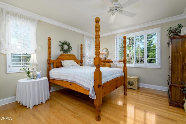 bedroom featuring baseboards, crown molding, light wood-style floors, and ceiling fan