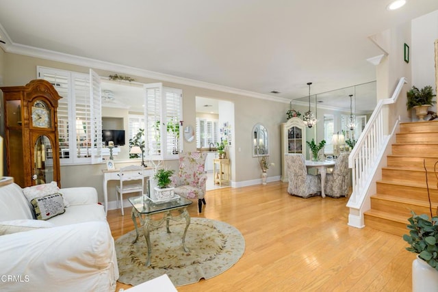 living room featuring stairs, wood finished floors, baseboards, and ornamental molding