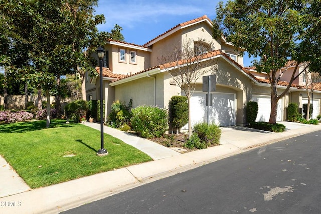 mediterranean / spanish-style home with a tile roof, stucco siding, a front yard, and an attached garage