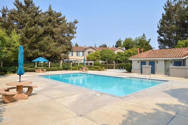 community pool featuring fence and a patio
