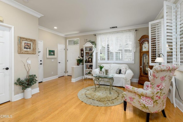 interior space featuring baseboards, visible vents, crown molding, and wood finished floors