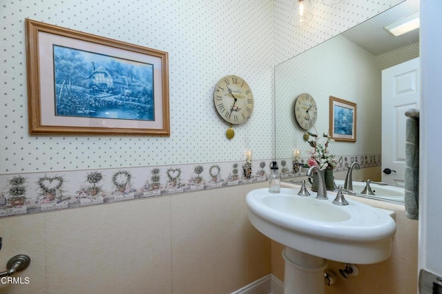 bathroom with a sink and wallpapered walls