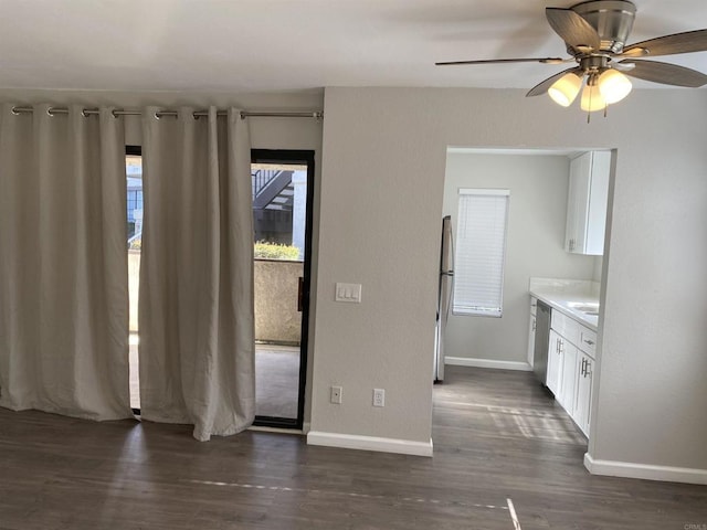 interior space with dark wood-type flooring, baseboards, and ceiling fan