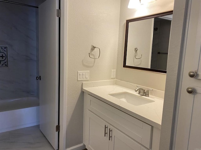 bathroom with vanity, a textured wall, and marble finish floor