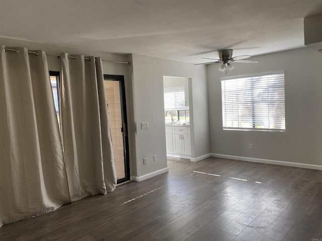 spare room with a sink, baseboards, wood finished floors, and a ceiling fan