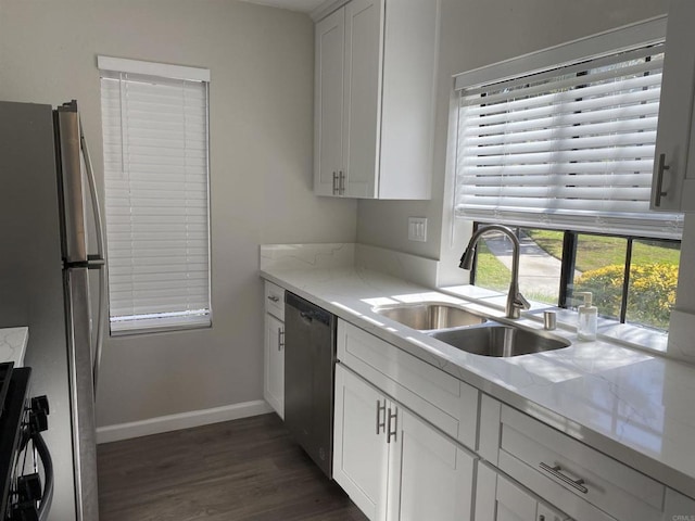 kitchen featuring dark wood-style floors, white cabinetry, stainless steel appliances, and a sink