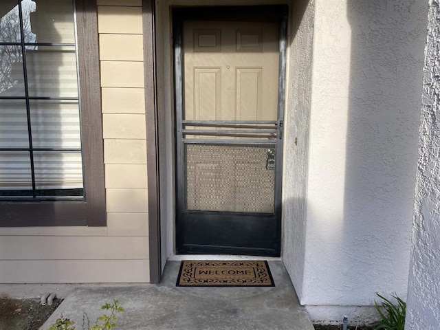 view of exterior entry with stucco siding