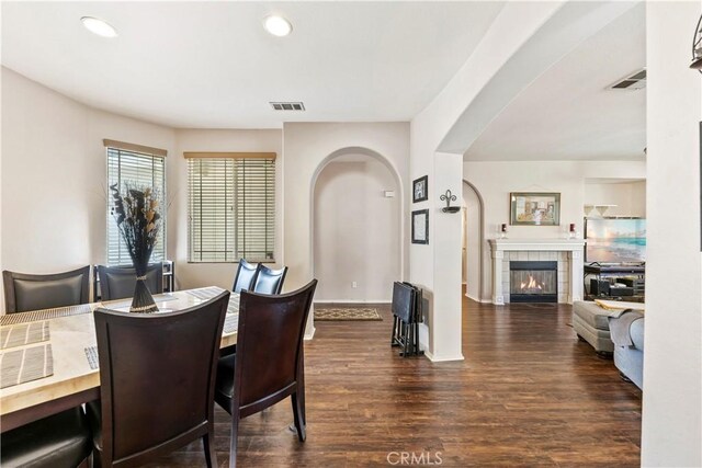 28183 Rocky Cove Dr, Menifee, CA 92585 - dining room with wood finished floors, recessed lighting, a tiled fireplace, and arched walkways