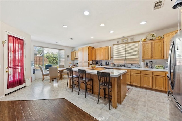 28183 Rocky Cove Dr, Menifee, CA 92585 - kitchen featuring light countertops, a center island, a breakfast bar, recessed lighting, and freestanding refrigerator