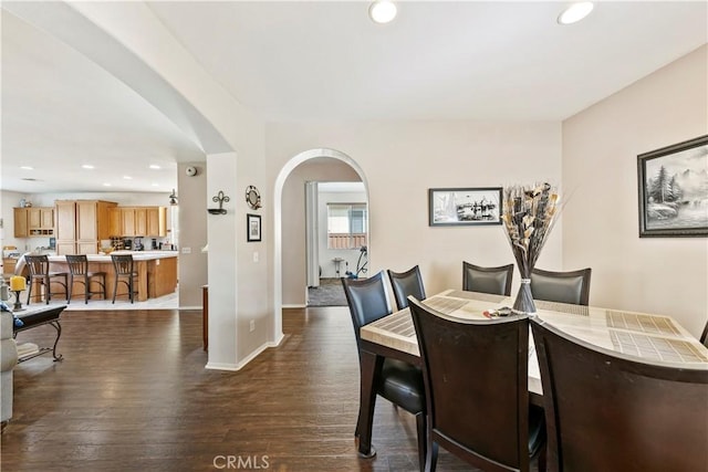 28183 Rocky Cove Dr, Menifee, CA 92585 - dining area with arched walkways, recessed lighting, and dark wood-type flooring
