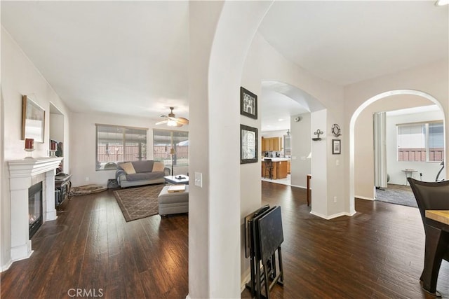 28183 Rocky Cove Dr, Menifee, CA 92585 - living room featuring arched walkways, hardwood / wood-style flooring, ceiling fan, and a glass covered fireplace