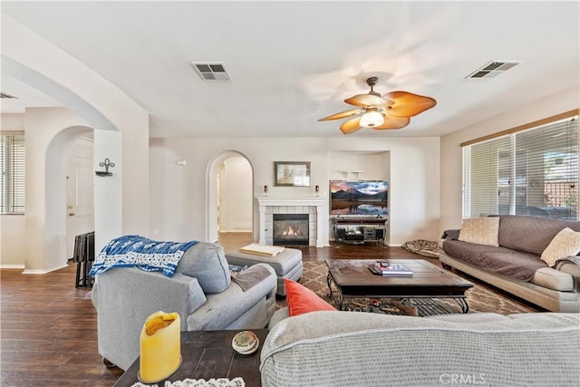 28183 Rocky Cove Dr, Menifee, CA 92585 - living room featuring arched walkways, dark wood-style flooring, a ceiling fan, and a fireplace