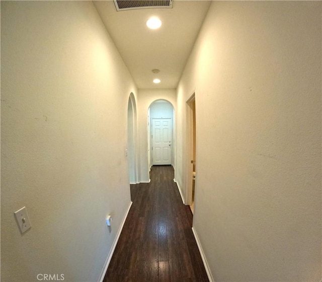 28183 Rocky Cove Dr, Menifee, CA 92585 - corridor featuring arched walkways, dark wood-style flooring, and recessed lighting