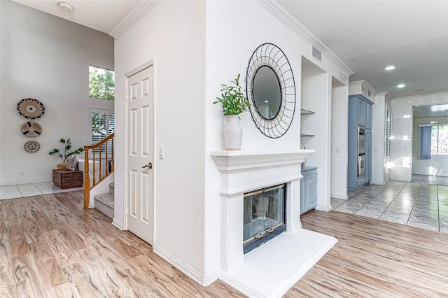2768 Somerset Pl, Rowland Heights, CA 91748 - unfurnished living room featuring a glass covered fireplace, ornamental molding, stairs, and light wood-style flooring