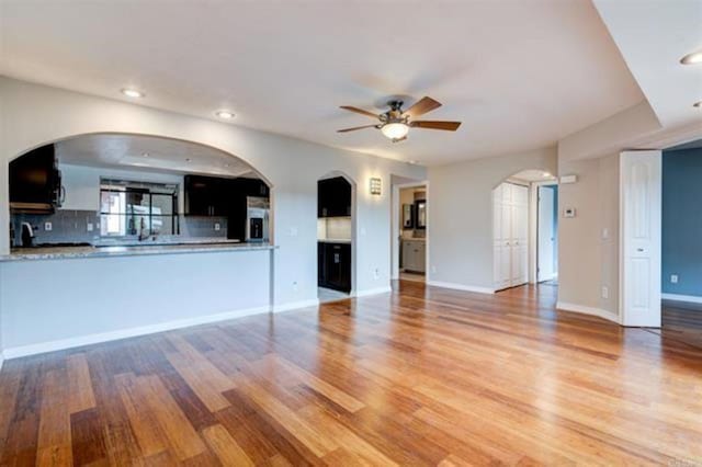 unfurnished living room with recessed lighting, light wood-style flooring, baseboards, and ceiling fan