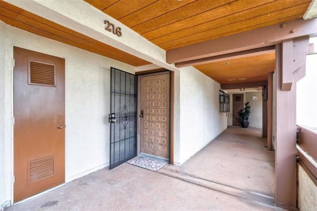 property entrance with visible vents and stucco siding