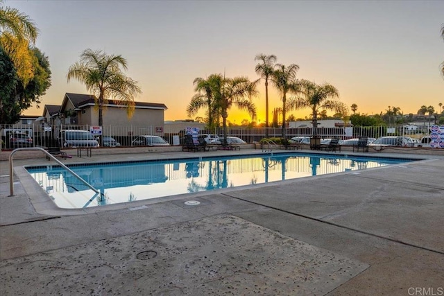 pool with a patio area and fence