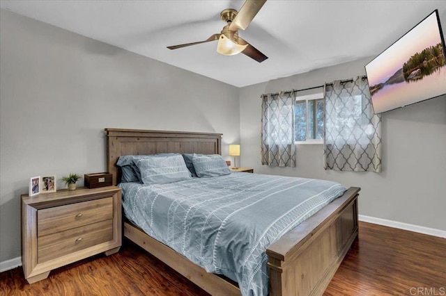 bedroom with dark wood finished floors, a ceiling fan, and baseboards