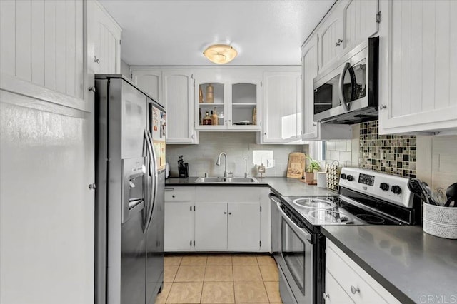 kitchen with a sink, stainless steel appliances, backsplash, and white cabinetry