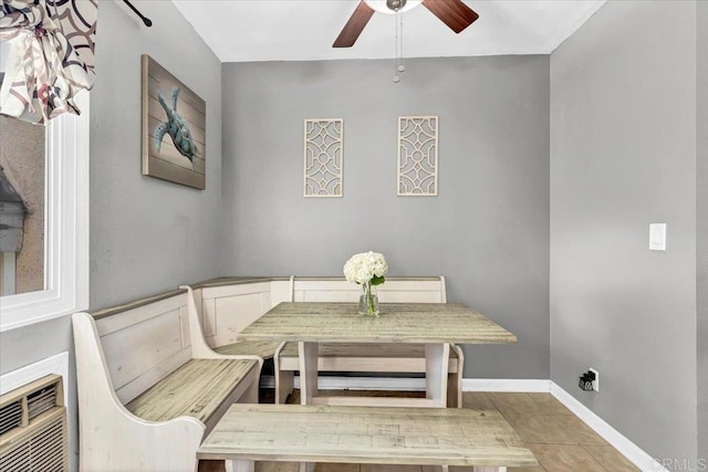 dining area with breakfast area, baseboards, and ceiling fan