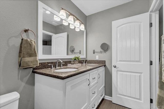 full bathroom featuring double vanity, toilet, and a sink