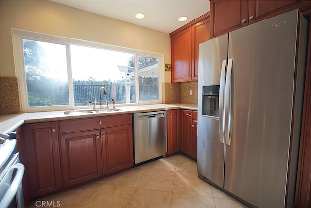 kitchen featuring a sink, stainless steel appliances, recessed lighting, brown cabinetry, and backsplash
