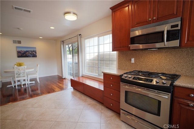 kitchen with recessed lighting, visible vents, stainless steel appliances, and decorative backsplash