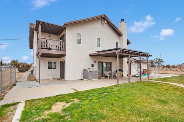 rear view of property with stucco siding, a yard, and a gate