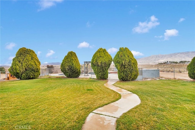 view of yard featuring a mountain view and fence