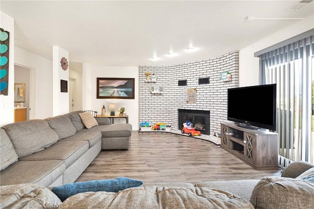 living area with visible vents, wood finished floors, and a fireplace