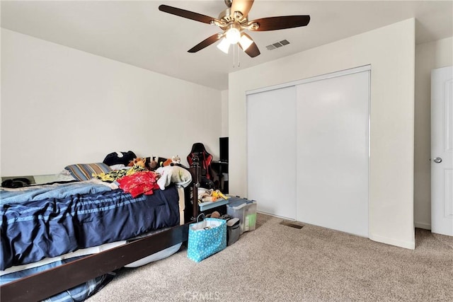 bedroom featuring a closet, visible vents, a ceiling fan, and carpet floors