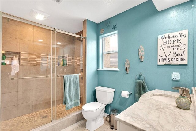 bathroom featuring vanity, toilet, a shower stall, and tile patterned flooring