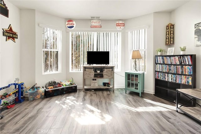 sitting room featuring visible vents, baseboards, and wood finished floors