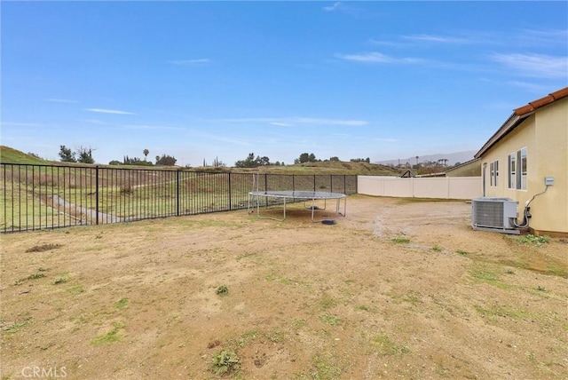 222 Garden Air Ct, Calimesa, CA 92320 - view of yard featuring a trampoline, a fenced backyard, and central AC