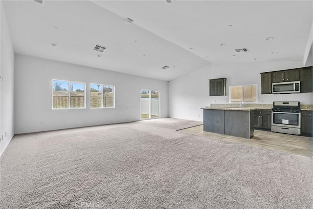 222 Garden Air Ct, Calimesa, CA 92320 - unfurnished living room featuring visible vents, light carpet, and lofted ceiling